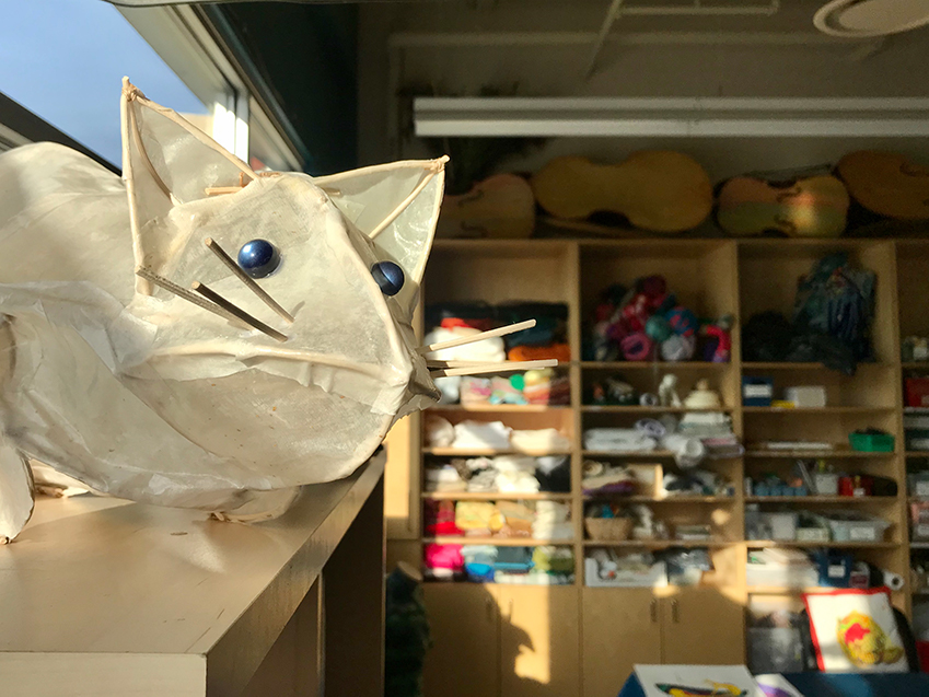 A paper cat sculpture by Holly Sabourin watches over the new fabric studio