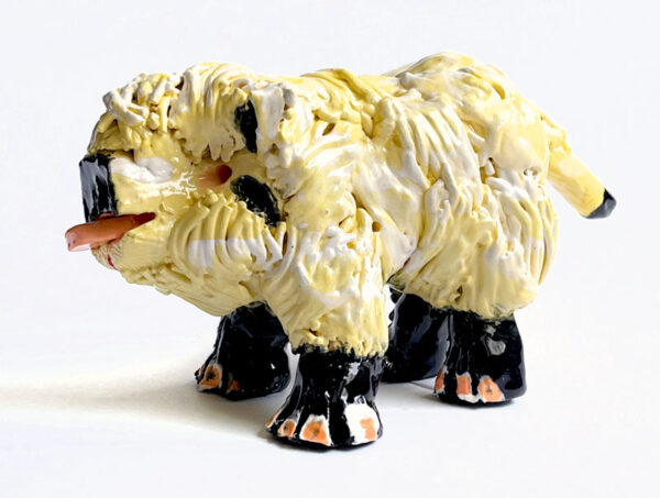 Side view of yellow ceramic highland cow sculpture