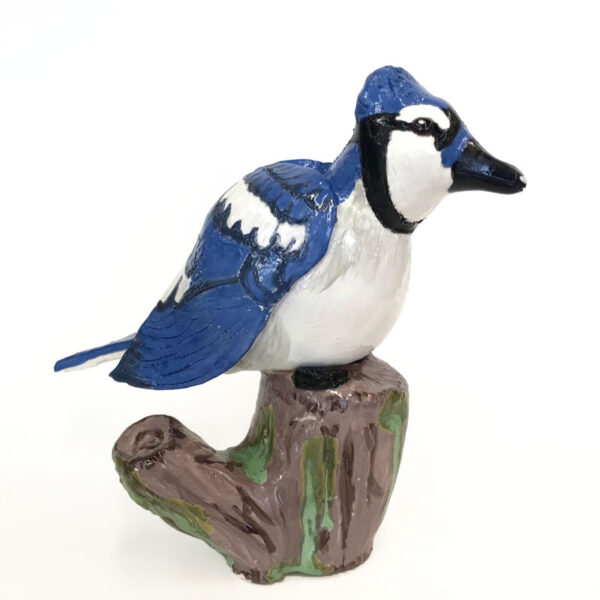 Ceramic sculpture of a blue jay on a stump by Holly Sabourin