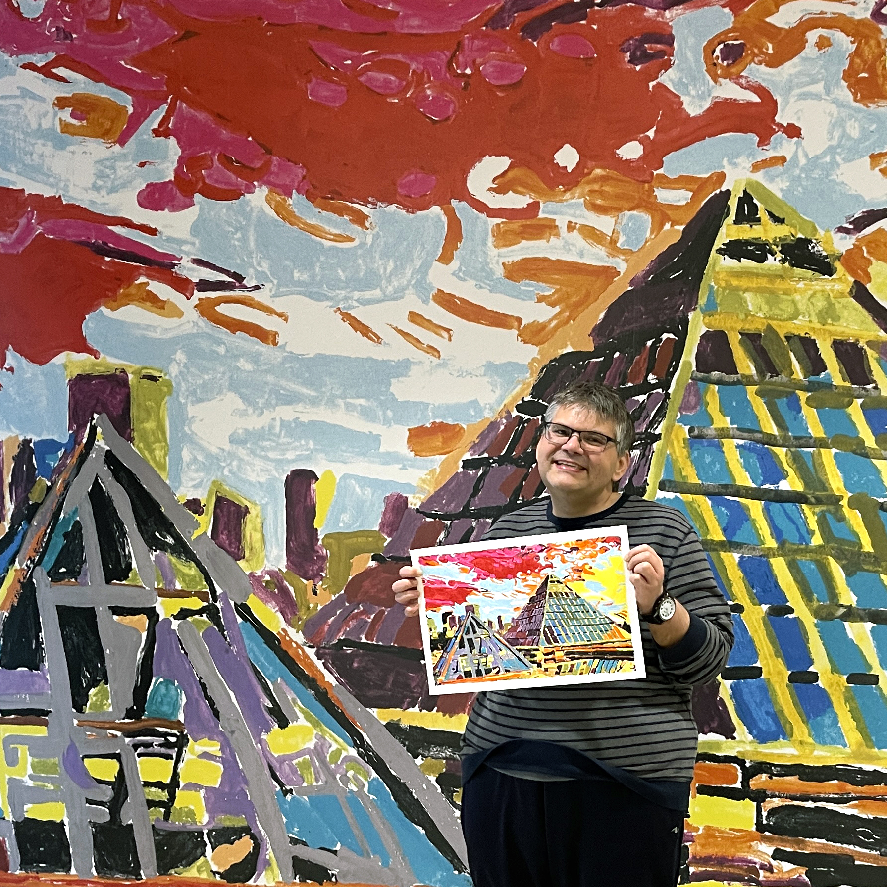 Jamie standing in front of his mural of the Muttart Conservatory