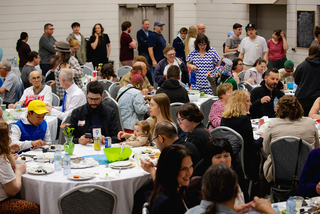 Patrons luncheon 2025 Room full of people sitting at tables and standing and mingling